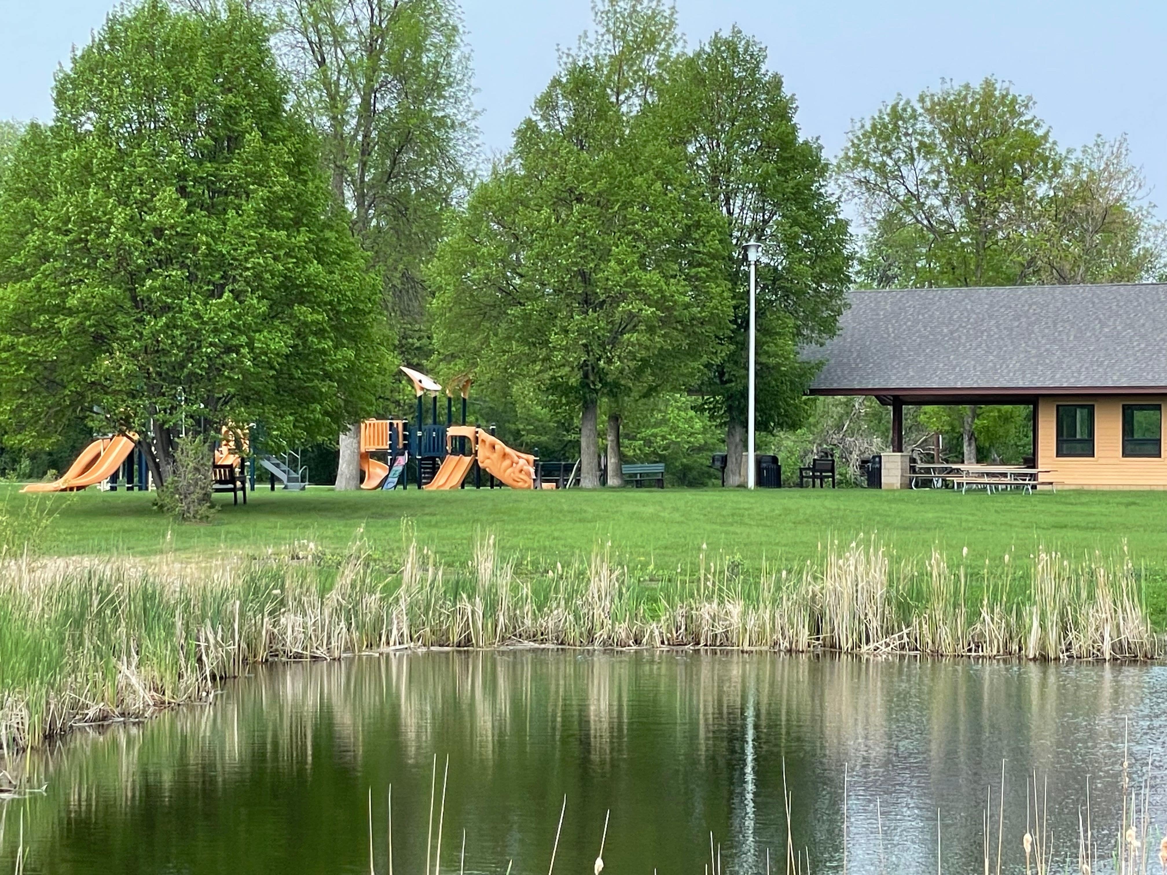 One of the park's picnic shelters is near a children's playset. 